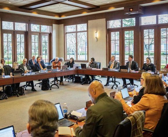 a board of regents meeting taking place in a large room